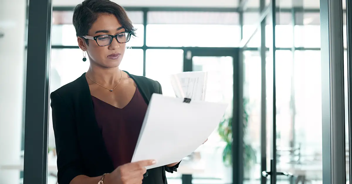 femme d'affaires debout seule au bureau et lisant des documents