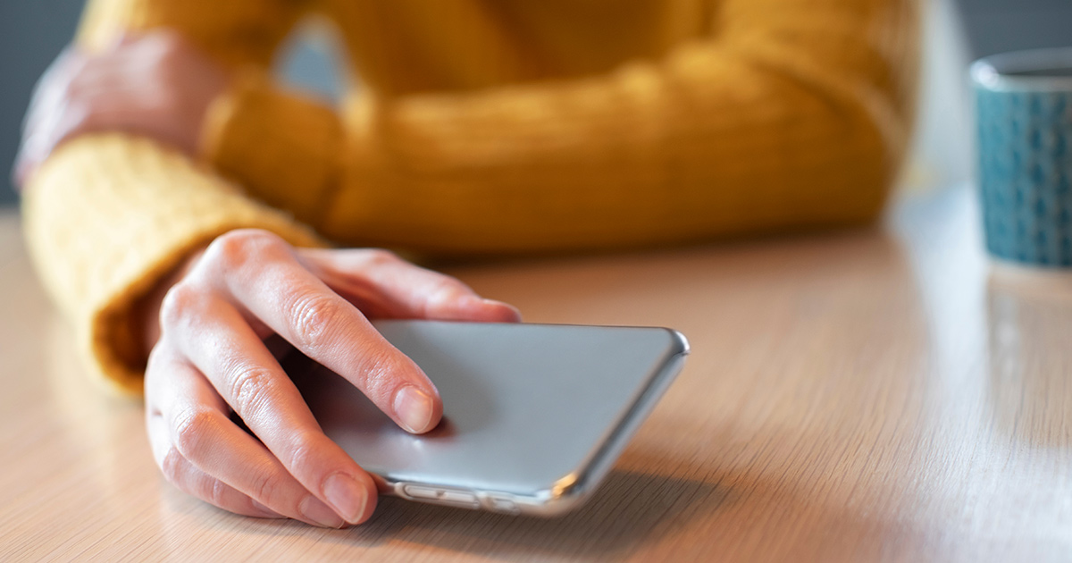 Femme concernée portant un téléphone portable sur la table