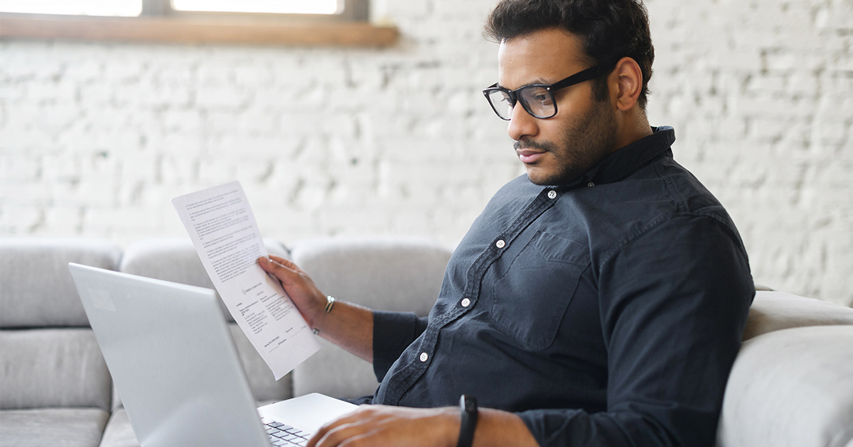 man sits on the couch using laptop for remote work