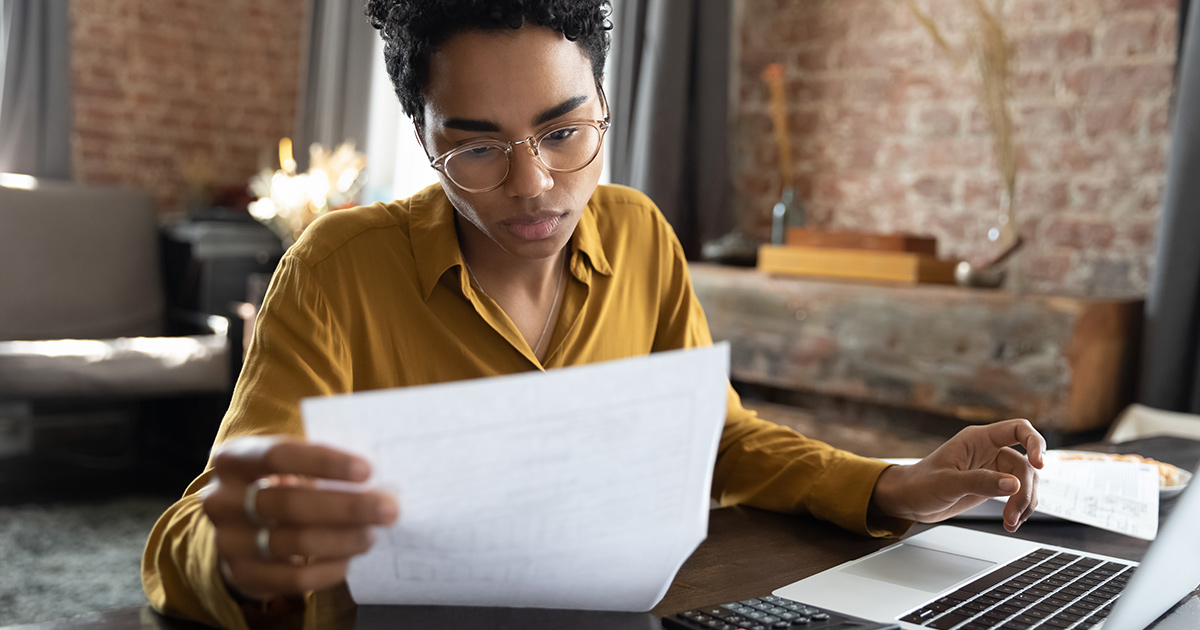 Femme regardant à travers des documents papier gérant des affaires commerciales