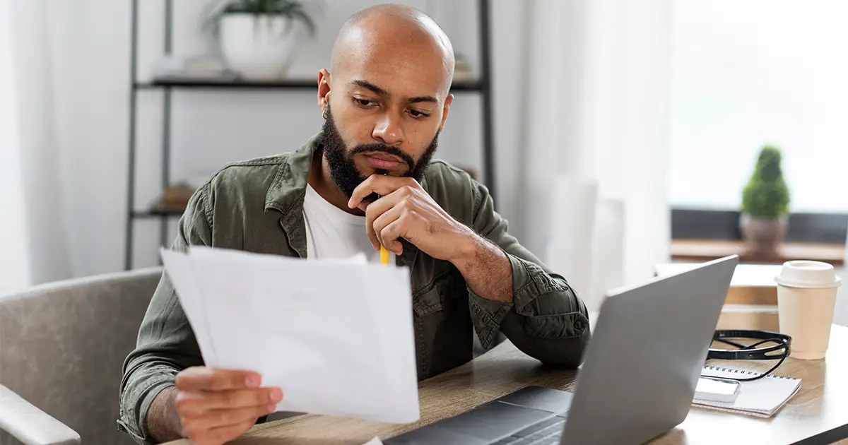 Vérifier des documents en lisant des rapports financiers tout en étant assis au bureau à la maison