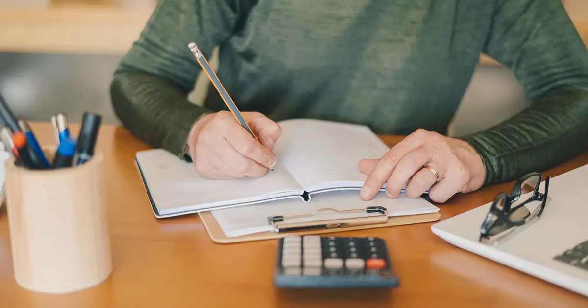 person working on finances with a calculator