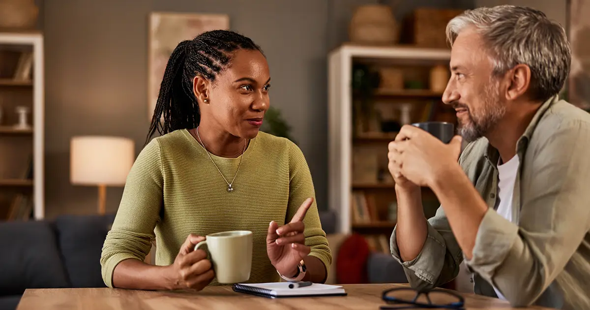 Deux personnes sont en pleine conversation tout en dégustant une boisson réconfortante à leur table