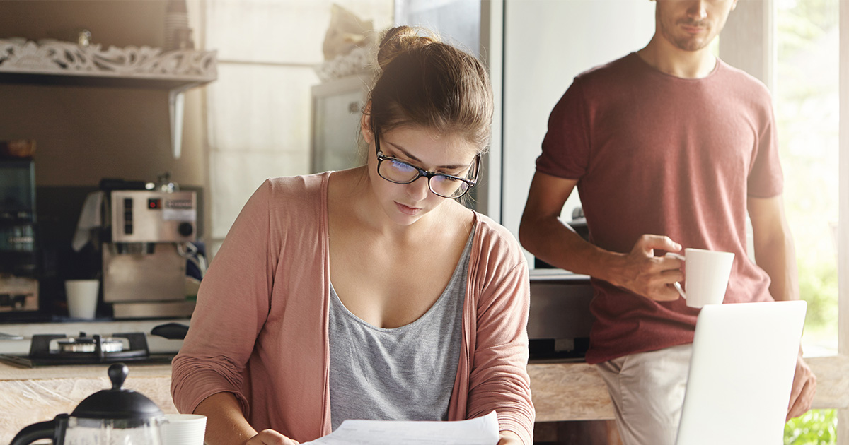 Jeune femme faisant le budget familial et les finances avec son mari à la maison.