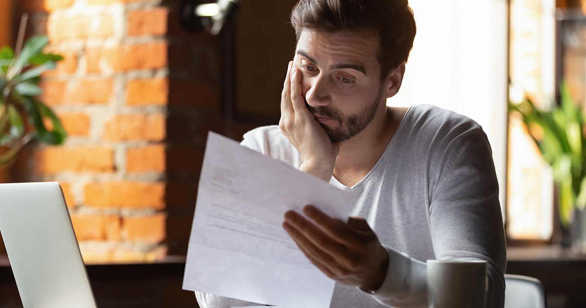 Un jeune homme lit une lettre dans un café.