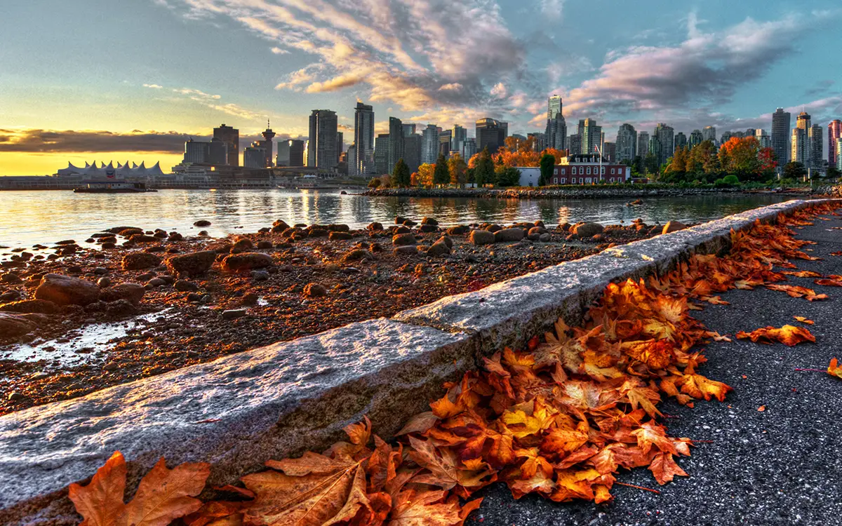 view of vancouver city skyline from beach at sunset