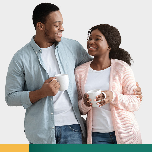 Couple smiling while holding cups of coffee